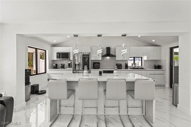 4411 Rose St, Valrico, FL 33596 - kitchen with stainless steel appliances, wall chimney range hood, a sink, light marble finish flooring, and lofted ceiling