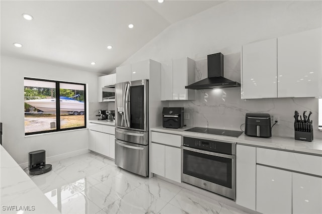 4411 Rose St, Valrico, FL 33596 - kitchen featuring stainless steel appliances, wall chimney exhaust hood, modern cabinets, white cabinetry, and vaulted ceiling
