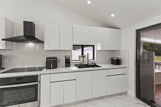 4411 Rose St, Valrico, FL 33596 - kitchen featuring wall chimney exhaust hood, oven, a sink, black electric stovetop, and white cabinetry