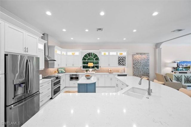 2026 Merlin Ct, Naples, FL 34105 - kitchen with appliances with stainless steel finishes, a sink, crown molding, a center island, and decorative backsplash