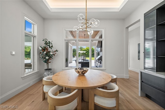 115 E Ave, Naples, FL 34108 - dining area featuring a chandelier, light wood-style floors, and baseboards
