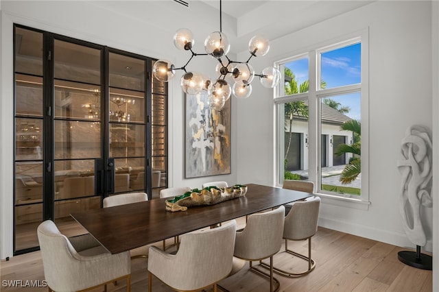 115 E Ave, Naples, FL 34108 - dining space featuring light wood-style flooring, baseboards, and a chandelier