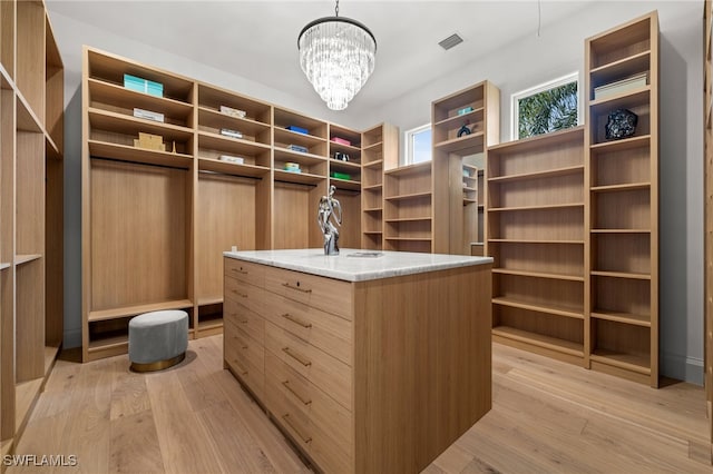 115 E Ave, Naples, FL 34108 - walk in closet with light wood-style floors and a chandelier