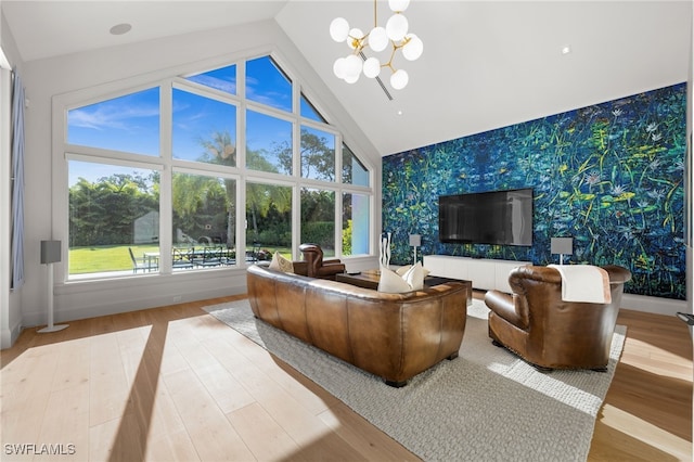 115 E Ave, Naples, FL 34108 - living area featuring wallpapered walls, an accent wall, a chandelier, baseboards, and healthy amount of natural light