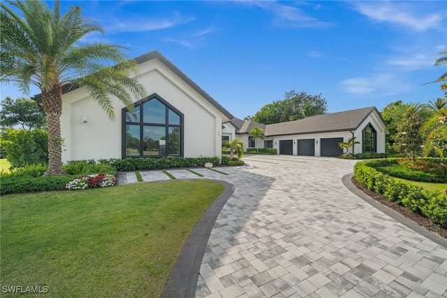 115 E Ave, Naples, FL 34108 - view of front of property featuring stucco siding, a front lawn, decorative driveway, and a garage