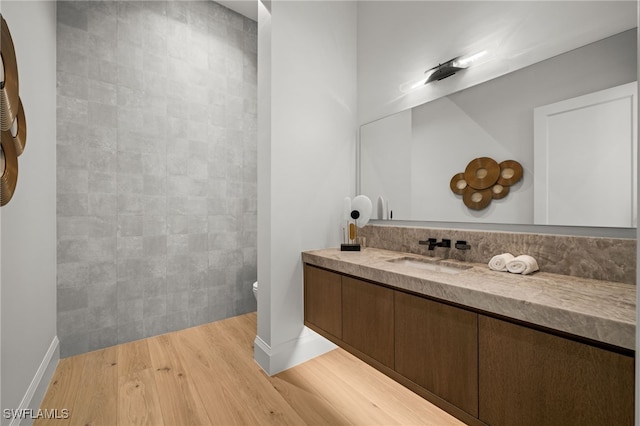 115 E Ave, Naples, FL 34108 - full bath with wood finished floors, vanity, toilet, baseboards, and tile walls