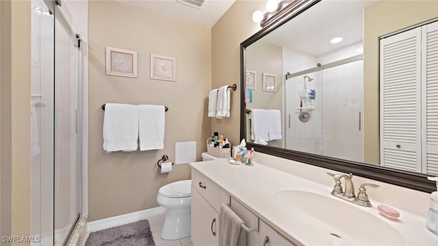 bathroom with a shower stall, vanity, tile patterned floors, toilet, and a closet