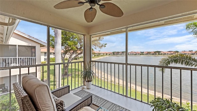 sunroom / solarium with a water view and ceiling fan