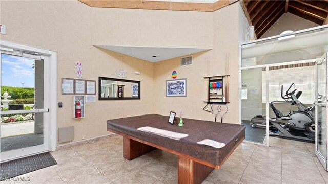rec room with healthy amount of natural light, high vaulted ceiling, billiards, and light tile patterned floors