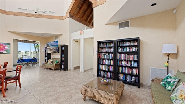 tiled living room with a towering ceiling and track lighting
