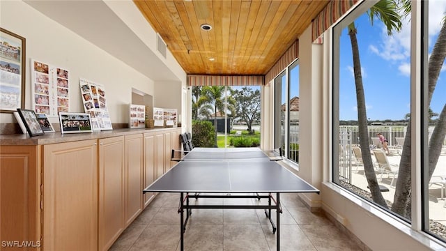 recreation room featuring wood ceiling and light tile patterned floors
