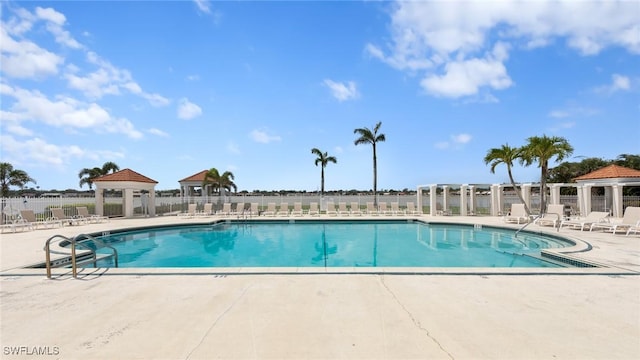 community pool with a gazebo, fence, and a patio