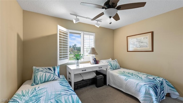 bedroom with carpet flooring, a textured ceiling, rail lighting, and a ceiling fan