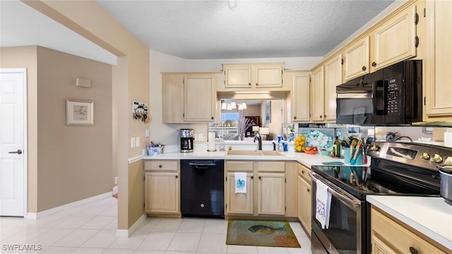 kitchen with black appliances, a sink, light brown cabinetry, and a textured ceiling