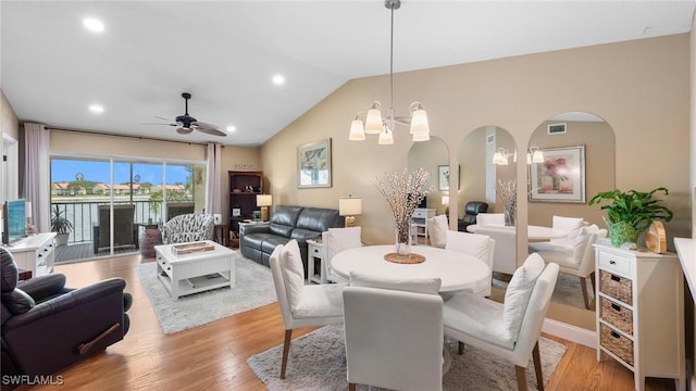 dining space with ceiling fan, light wood finished floors, arched walkways, recessed lighting, and lofted ceiling