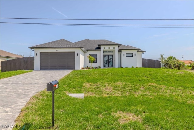 prairie-style house with stucco siding, an attached garage, and decorative driveway