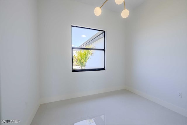 unfurnished room with baseboards