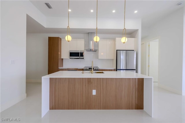 kitchen featuring stainless steel appliances, wall chimney exhaust hood, modern cabinets, white cabinets, and light countertops