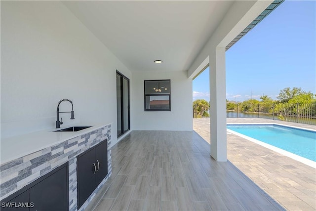view of patio with a sink and fence