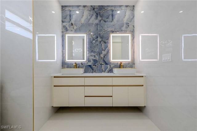 bathroom featuring double vanity, tile walls, and backsplash