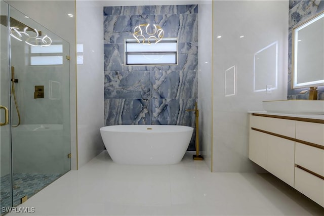full bath featuring tile walls, vanity, a shower stall, a freestanding bath, and tile patterned flooring