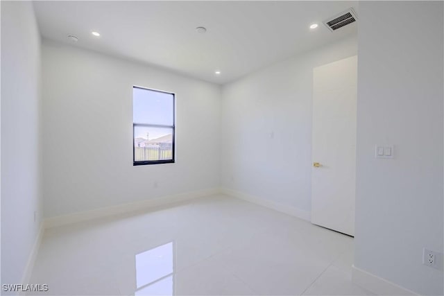 empty room featuring recessed lighting, tile patterned floors, and baseboards