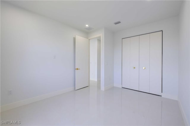 unfurnished bedroom with baseboards, recessed lighting, a closet, and tile patterned flooring
