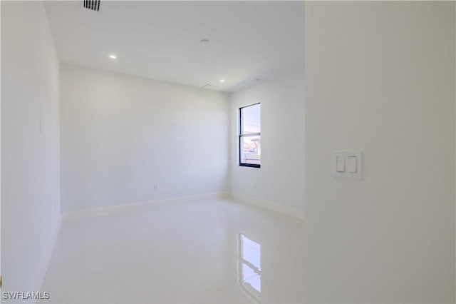 spare room with recessed lighting and baseboards