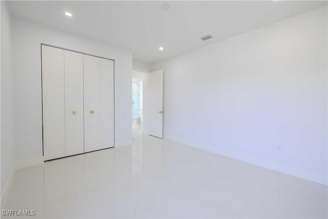 unfurnished bedroom with recessed lighting, a closet, and tile patterned flooring