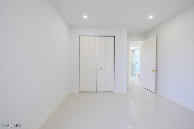 unfurnished bedroom featuring recessed lighting, tile patterned floors, a closet, and baseboards