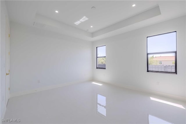 empty room with a tray ceiling and recessed lighting