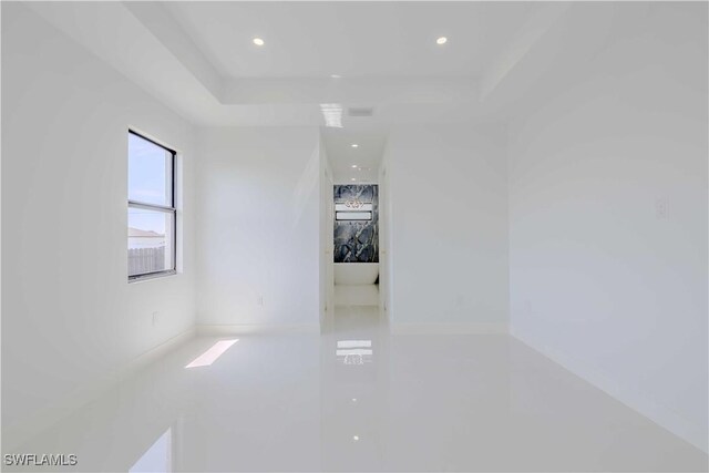 spare room with a tray ceiling and recessed lighting