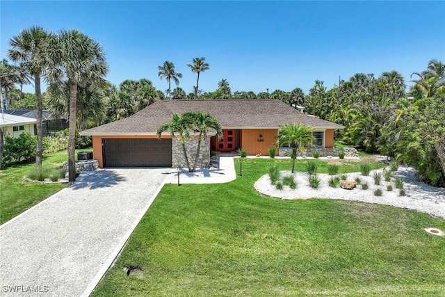 single story home featuring driveway, a garage, and a front yard