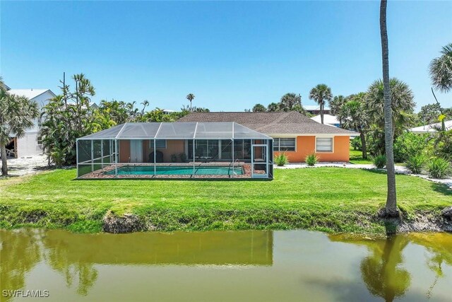 rear view of property with a yard, an outdoor pool, a water view, and glass enclosure
