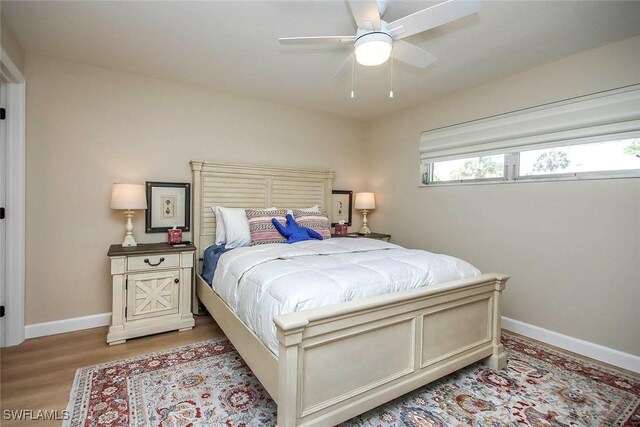 bedroom featuring light wood-style floors, baseboards, and ceiling fan
