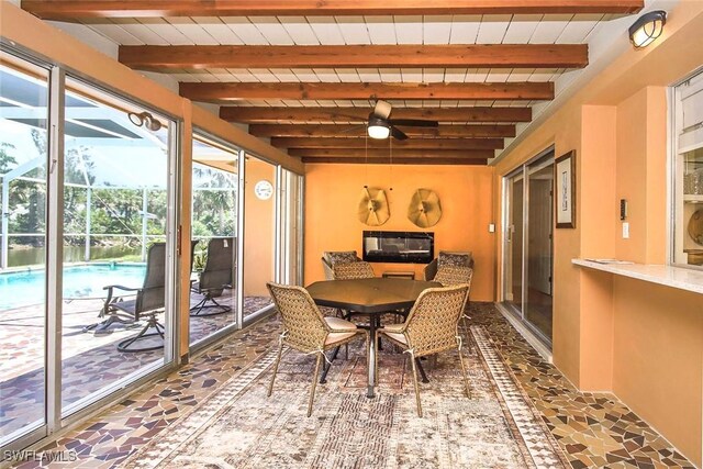 sunroom with healthy amount of natural light, beamed ceiling, and outdoor dining space