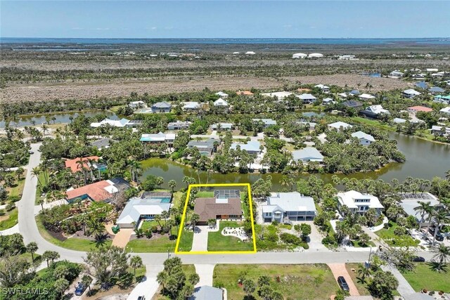 aerial view of residential area with property boundaries highlighted and a nearby body of water