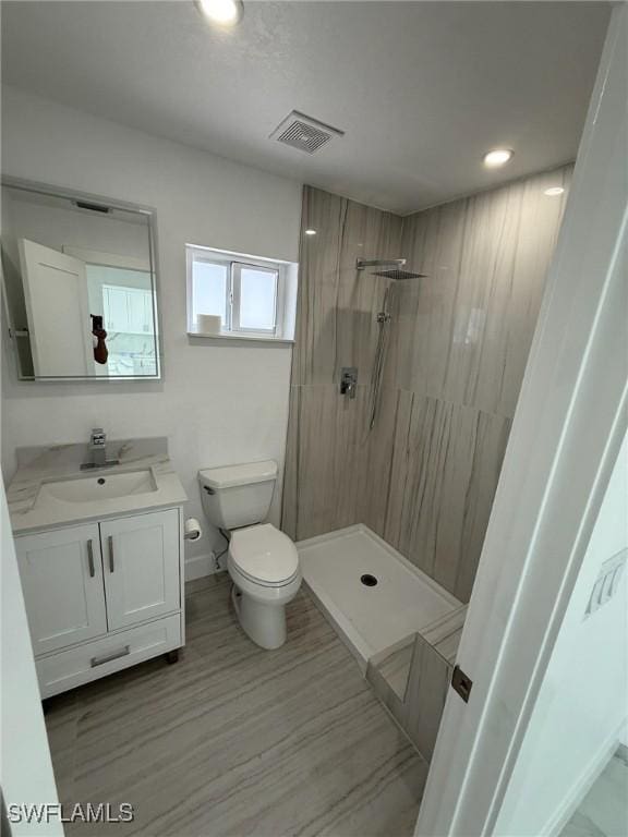 2823 Janet St, Matlacha, FL 33993 - bathroom with toilet, tiled shower, vanity, baseboards, and recessed lighting