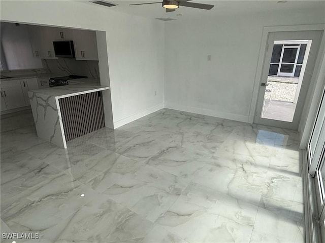 2823 Janet St, Matlacha, FL 33993 - kitchen with light marble finish floors, electric range, a ceiling fan, baseboards, and a peninsula