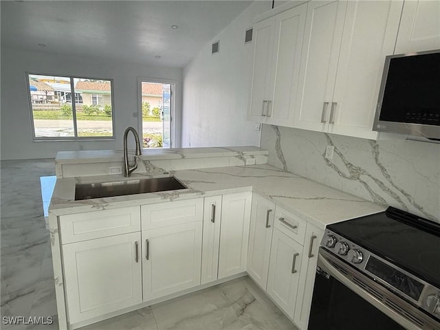2823 Janet St, Matlacha, FL 33993 - kitchen with appliances with stainless steel finishes, a sink, light marble finish flooring, light stone countertops, and white cabinetry