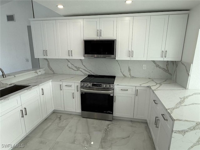 2823 Janet St, Matlacha, FL 33993 - kitchen featuring appliances with stainless steel finishes, a sink, light marble finish flooring, recessed lighting, and white cabinetry
