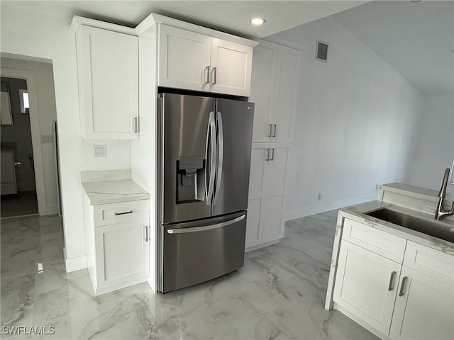 2823 Janet St, Matlacha, FL 33993 - kitchen featuring stainless steel fridge, light marble finish flooring, recessed lighting, white cabinetry, and light stone countertops
