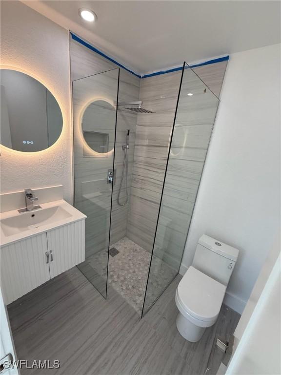 2823 Janet St, Matlacha, FL 33993 - bathroom featuring vanity, a walk in shower, wood finished floors, and recessed lighting