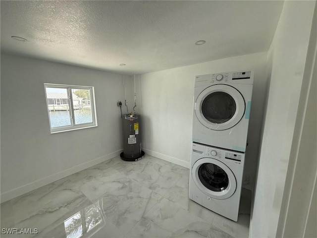 2823 Janet St, Matlacha, FL 33993 - laundry area with stacked washer / drying machine, electric water heater, marble look tiles, baseboards, and a textured ceiling