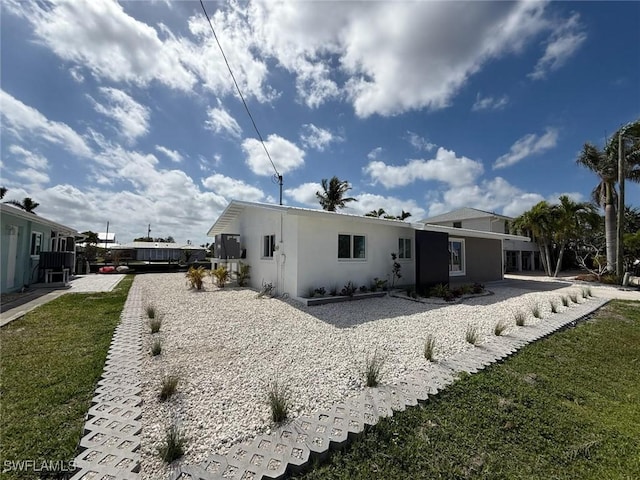 2823 Janet St, Matlacha, FL 33993 - rear view of house featuring stucco siding and a lawn