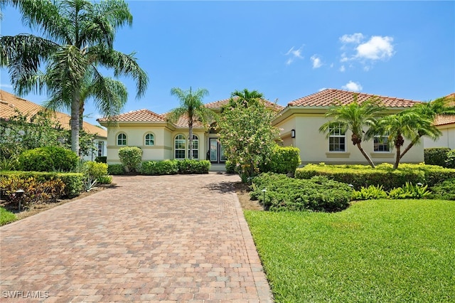 5687 Whispering Willow Way, Fort Myers, FL 33908 - mediterranean / spanish house with stucco siding, decorative driveway, a tile roof, and a front yard