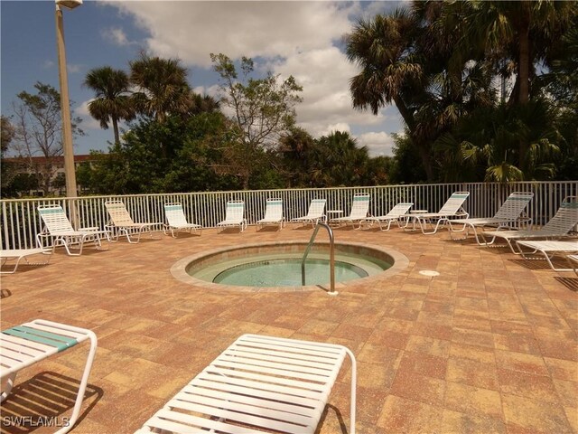 view of pool featuring a patio, fence, and a community hot tub