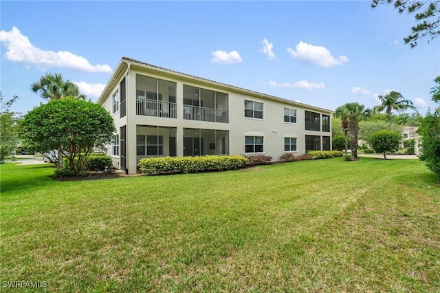rear view of property with stucco siding and a lawn