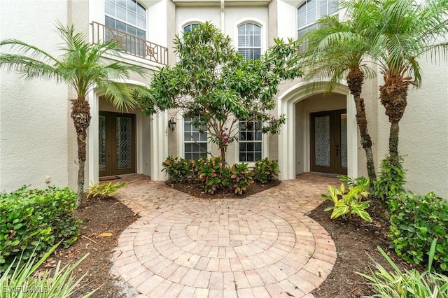 view of exterior entry with french doors and stucco siding