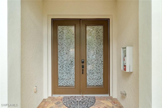 property entrance with french doors and stucco siding